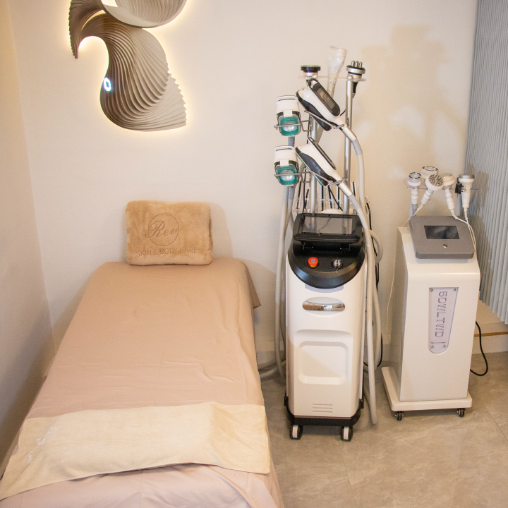 A softly lit treatment bed and care equipment at Reve